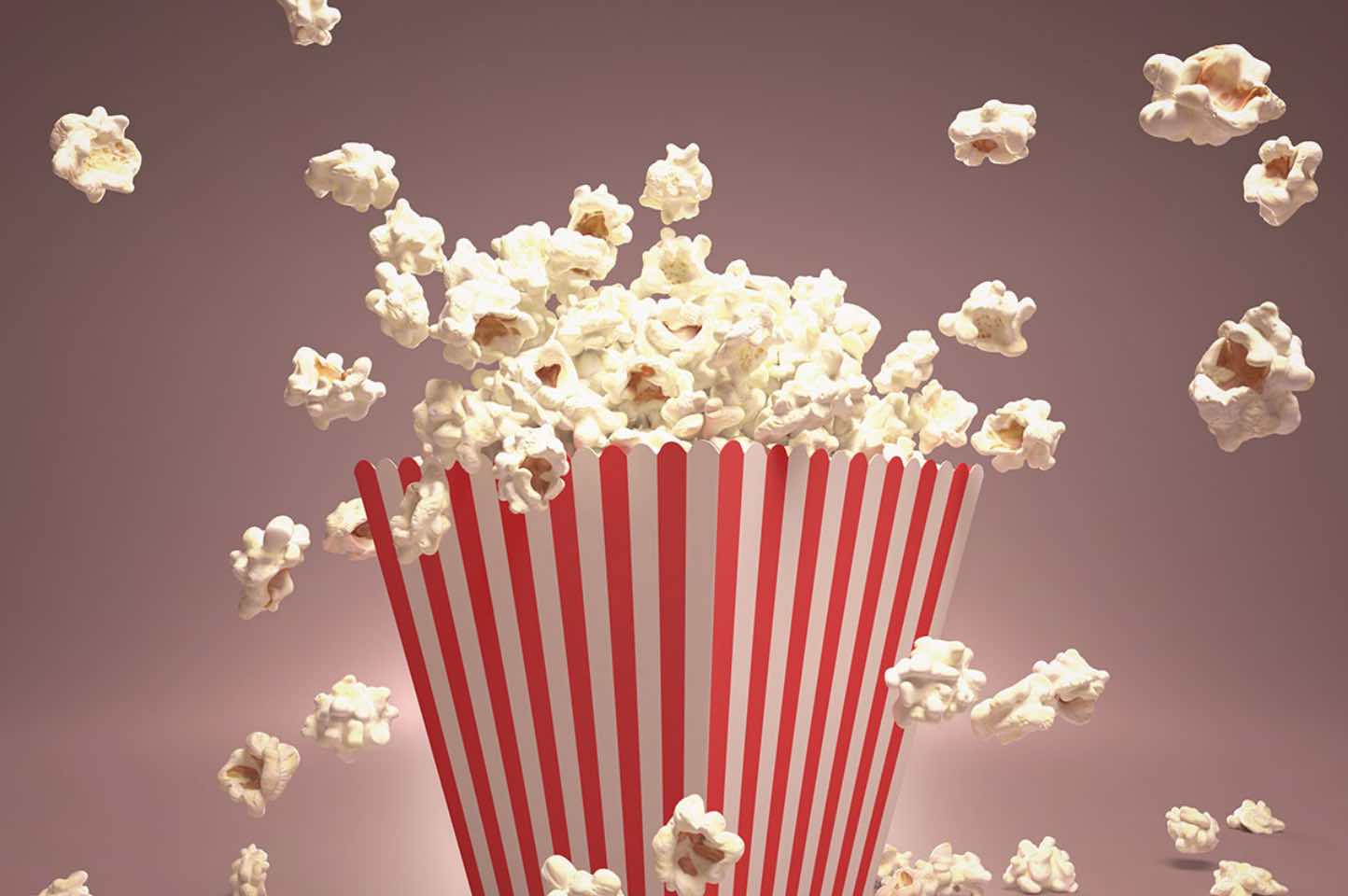 popcorn som flyger ur röd-vit-randig popcornbytta