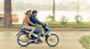 ett par som snabbt åker förbi på en moped