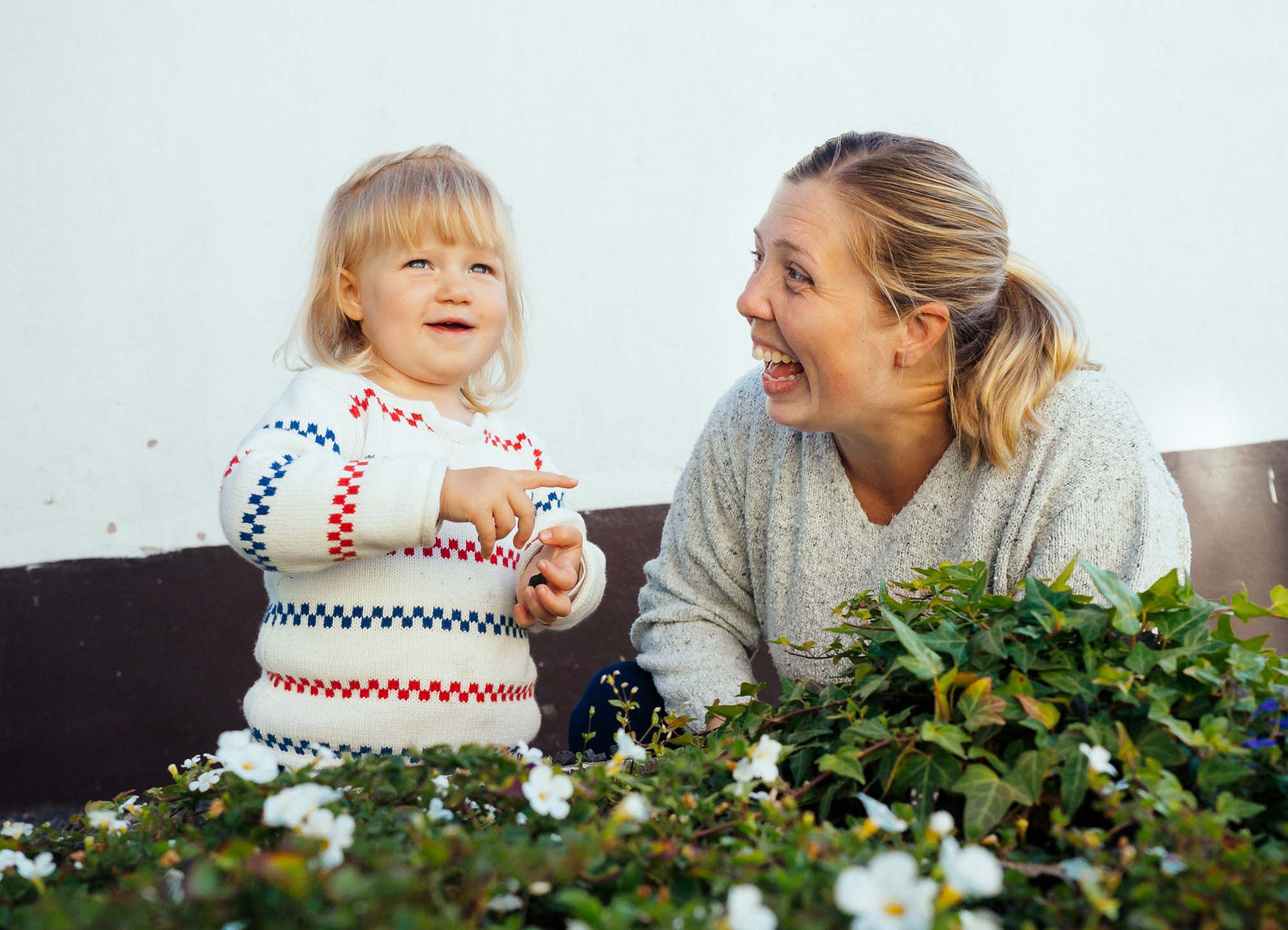 foto på en kvinna och en liten flicka mot en husvägg