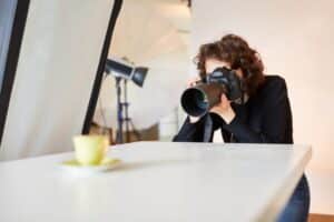 Fotograf med SLR-kamera som tar en bild av en produkt